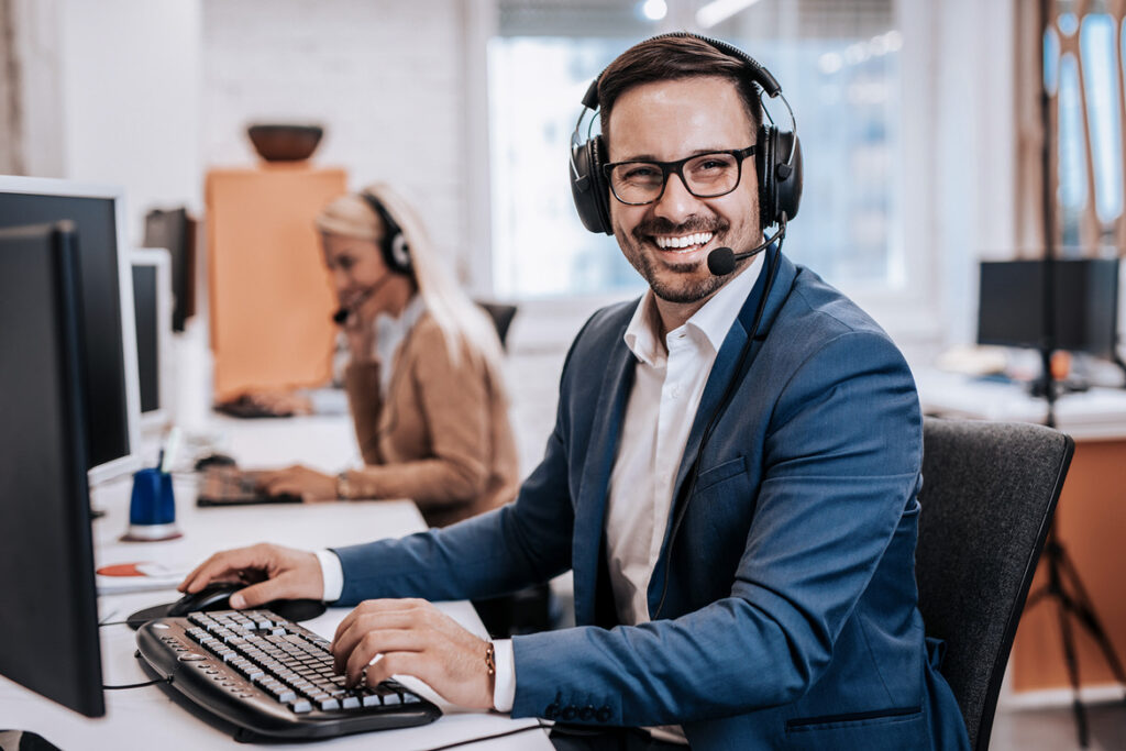 Handsome male customer service agent working in call center offi